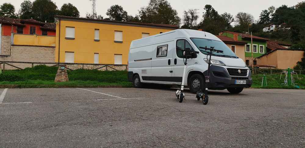 Furgoneta camper y patinetes elรฉctricos de Van and to Discover en el estacionamiento al inicio de la Senda del Oso