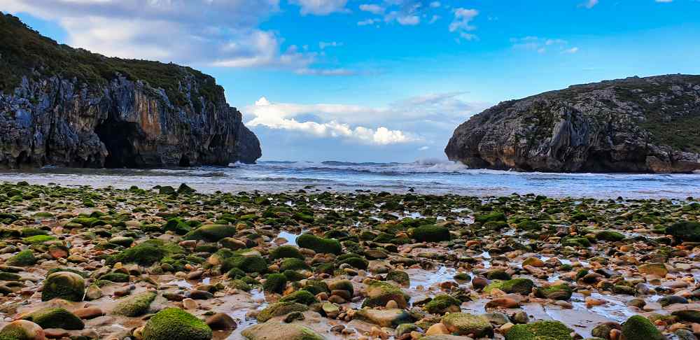 Paisaje de rocas y acantilados en la Playa de las Cuevas del Mar durante la ruta en furgoneta camper por Asturias de Juanma y Elena de Van and to Discover