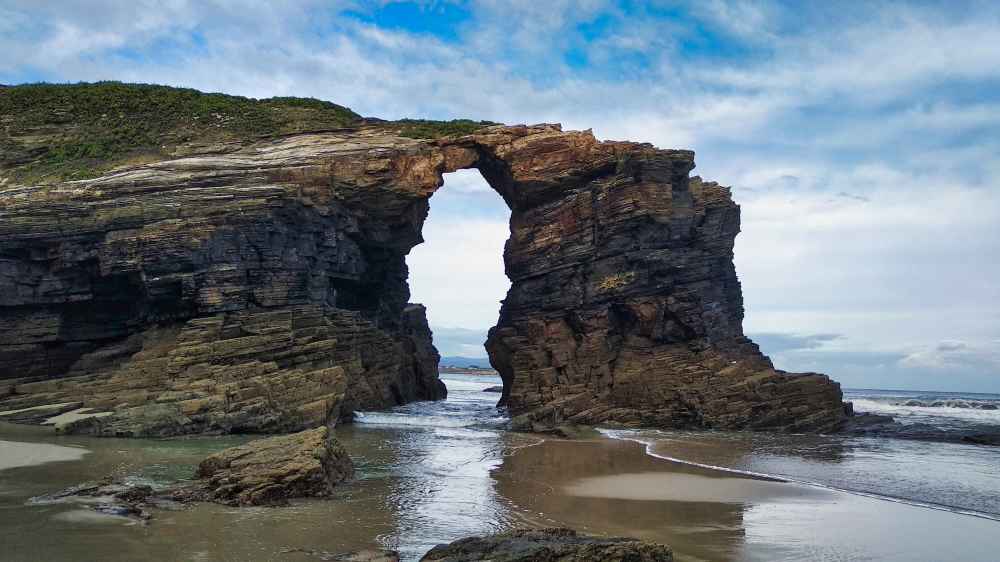 Arco de roca natural moldeado por el mar en la Playa de las Catedrales, monumento natural de Galicia