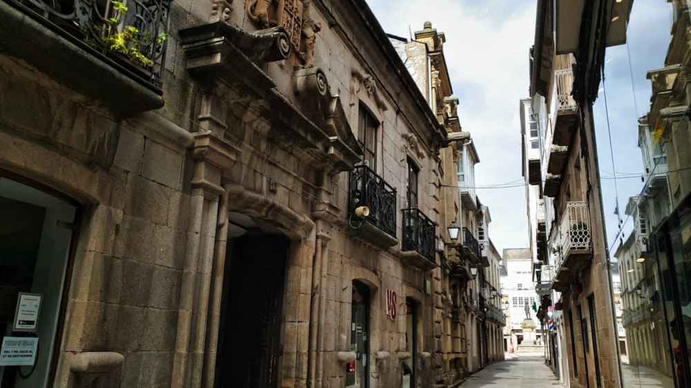 Callejón empedrado con casas tradicionales de piedra en el casco histórico de Vivero durante el viaje en furgoneta camper a Galicia de Van and to Discover