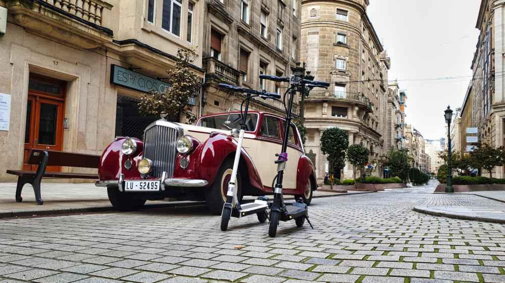 Patinetes eléctricos de Van and to Discover y coche de época en una de las calles empedradas del casco antiguo de Vigo