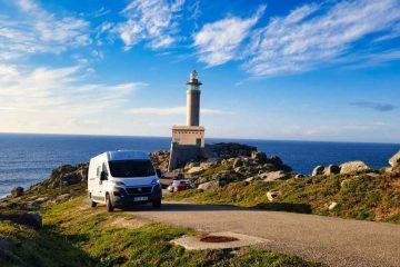 Furgoneta camper circulando por la carretera de acceso al Faro de Punta Nariga en la Costa da Morte, Galicia.
