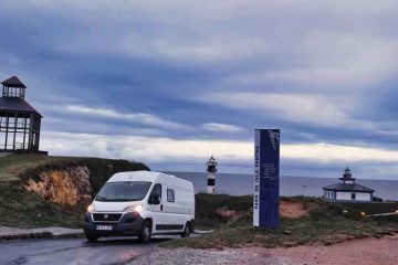 Furgoneta camper de Van and to Discover en Isla Pancha de Ribadeo con sus faros al fondo durante su viaje por Galicia