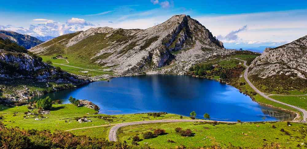 Vista del Lago Enol rodeado de prados y montañas en ruta de Juanma y Elena de Van and to Discover por Asturias en furgoneta camper