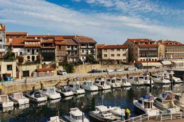 Barcos en el puerto pesquero de Llanes con las casas tradicionales asturianas - Van and to Discover