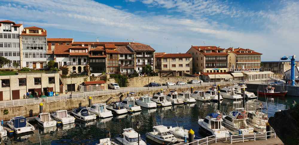 Barcos en el puerto pesquero de Llanes con las casas tradicionales asturianas - Van and to Discover