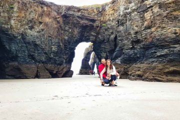 Juanma y Elena de Van and to Discover bajo los arcos de la roca en la Playa de las Catedrales de Galicia durante la marea baja