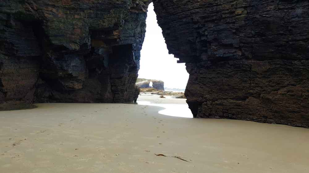 Vista desde el interior de una de las cuevas de roca de la Playa de las Catedrales durante la marea baja