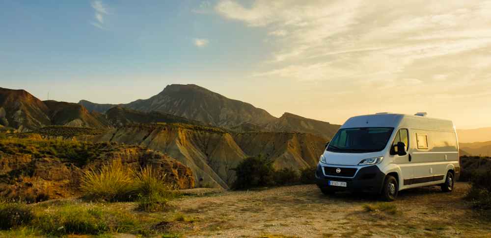 Furgoneta camper de Van and to Discover estacionada frente al desierto de las Tabernas en Almería.