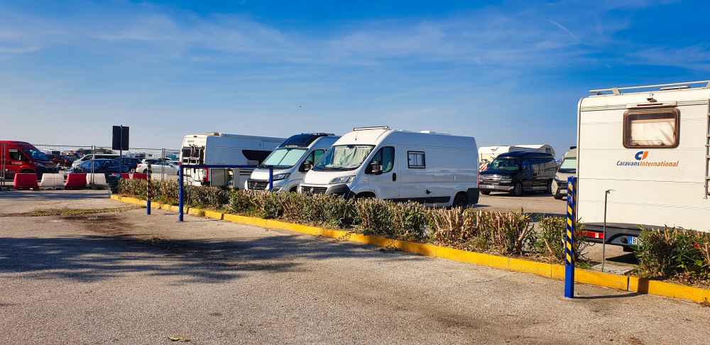 Furgoneta camper de Van and to Discover estacionada junto a otras furgonetas camper y autocaravanas en un área de autocaravanas en Venecia