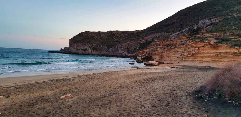 Vista de los acantilados y la orilla de la Cala del Plomo en Agua Amarga, una de las mejores playas que visitar en Almería en camper o autocaravana