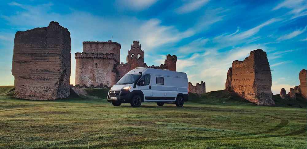 Furgoneta camper de Van and to Discover estacionada frente al Castillo de Turรฉgano