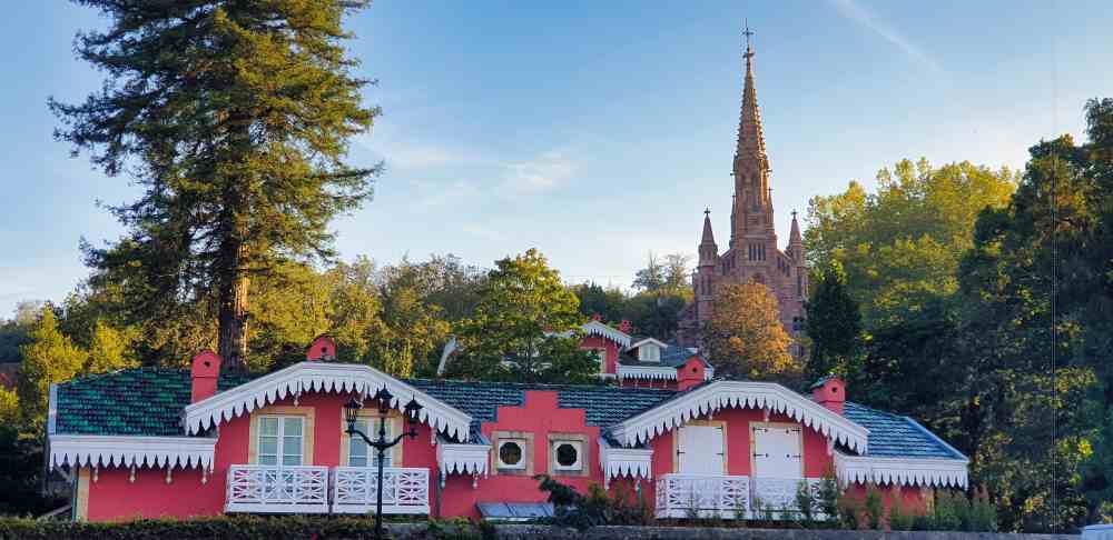 Torre de la Capilla Panteón de Comillas sobresaliendo tras los edificios tradicionales de la zona