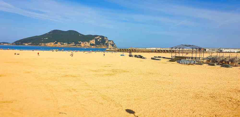 Playa de la Salvรฉ en Laredo con la localidad de Santoรฑa de fondo en la ruta por las Mejores Playas de Cantabria en furgoneta camper de Juanma y Elena de Van and to Discover